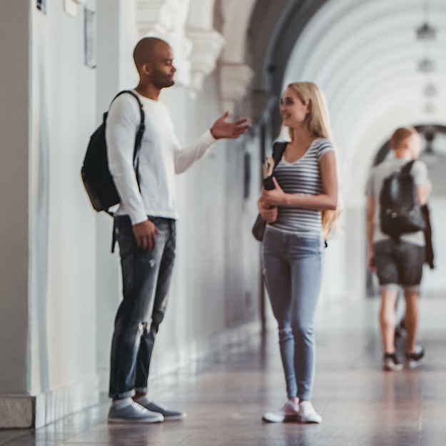 students talking in college hallway